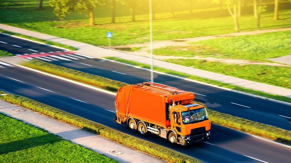 garbage truck driving down divided highway