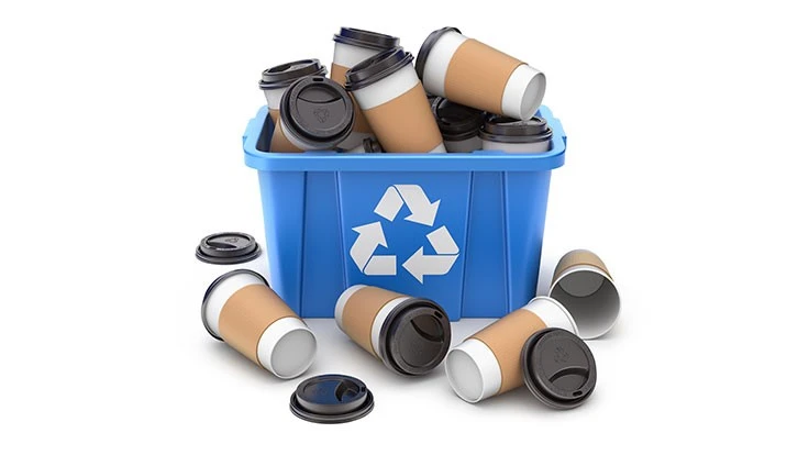 a recycling bin spilling over with paper cups