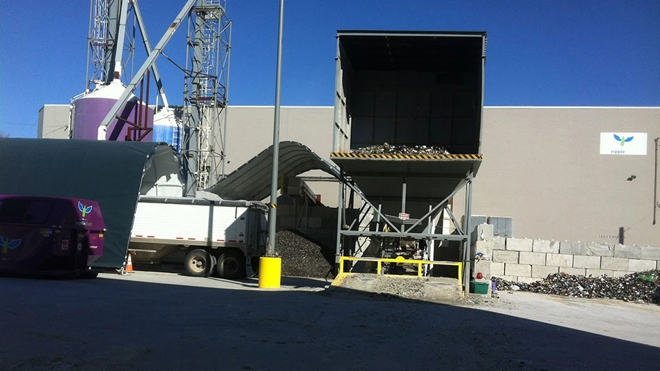 an industrial buidlign with a truck and a purple bin