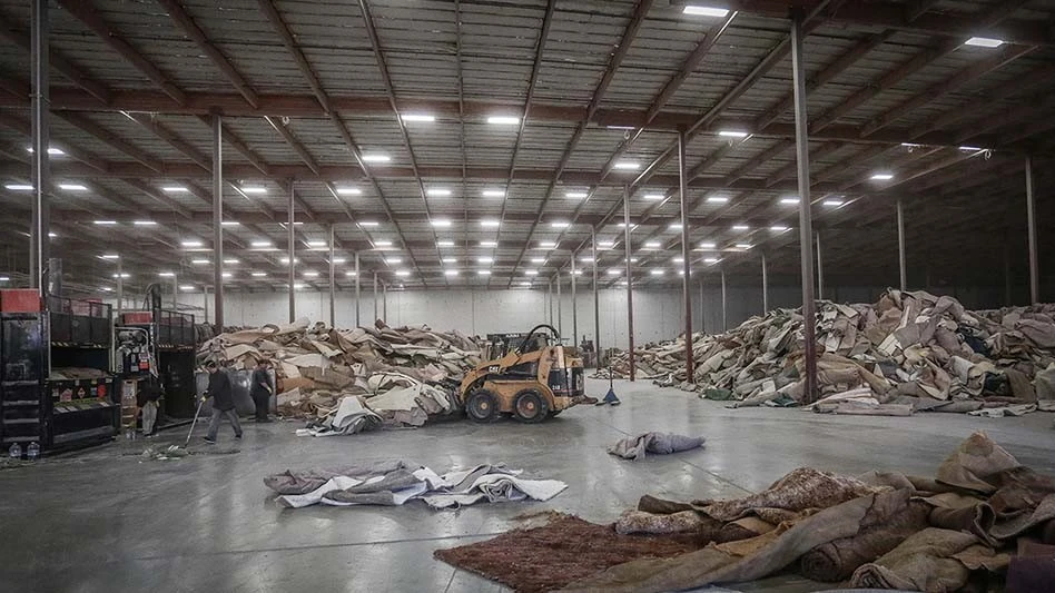 skid steer moves old carpeting