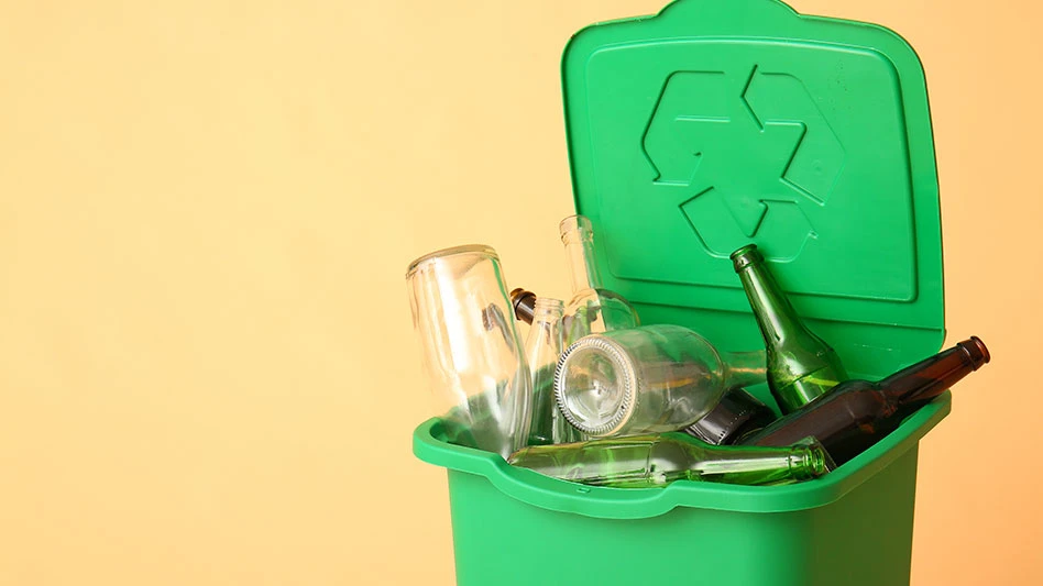 empty glass bottles in a green recycling bin