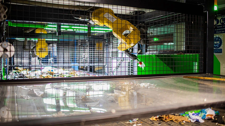 robotic arms above a conveyor belt loaded with paper