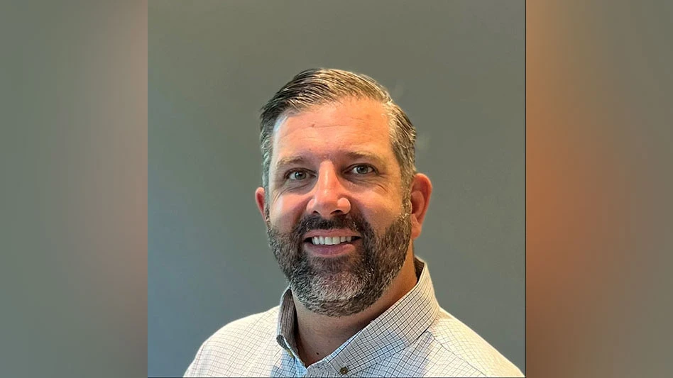 a smiling man with graying hair and beard