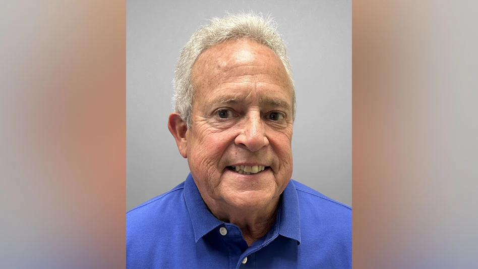 photo of white man with white hair in blue shirt smiling