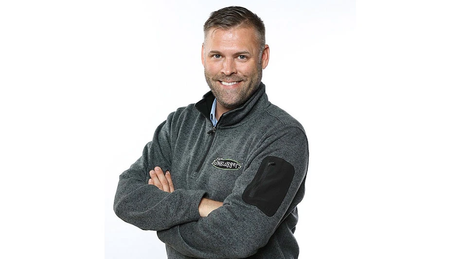 photo of a white man with arms crossed smiling