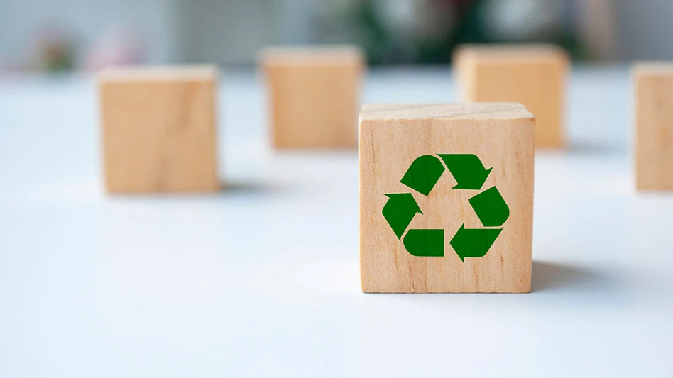 Recycle symbol on wooden cube with blur background.