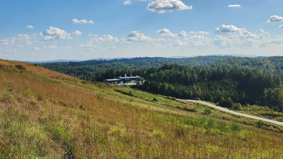 a grass covered landfill against a blu sky