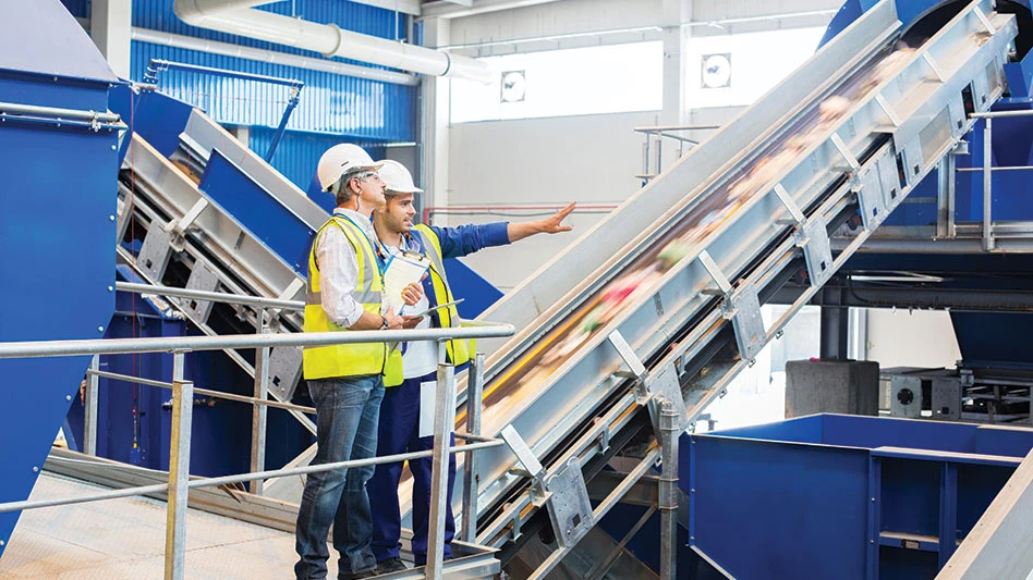 recycling facility workers pointing at conveyors in a material recovery facility