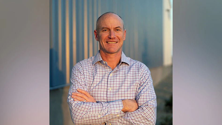 photo of a white bald man smiling, arms crossed