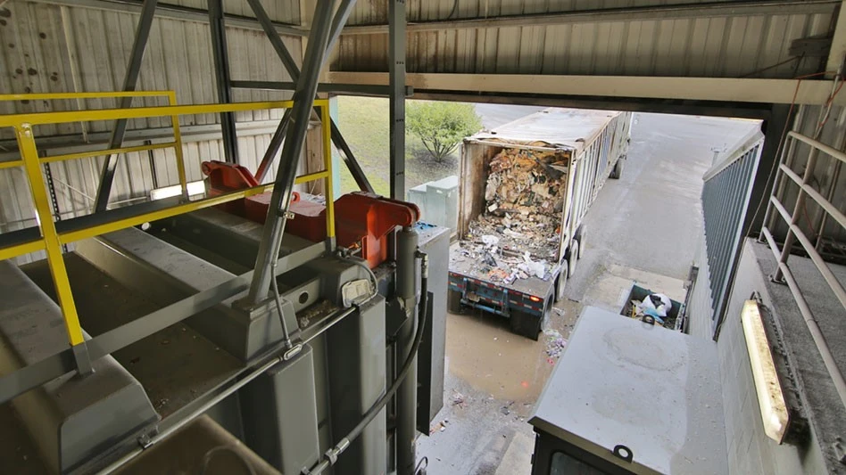 A truck loaded by a compactor